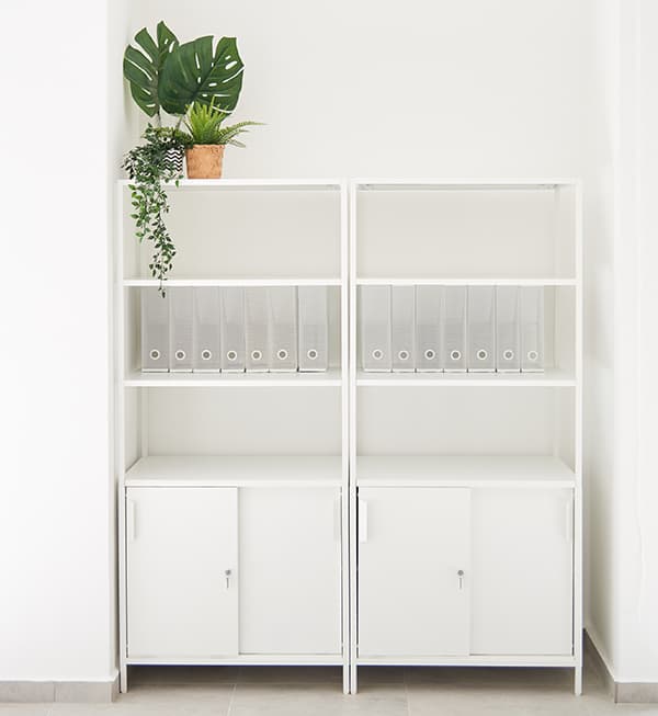 White storage cabinets with glasses displayed on the shelves.