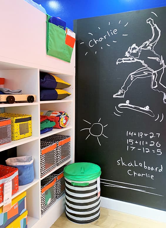 White storage shelves opposite a black wall chalk board