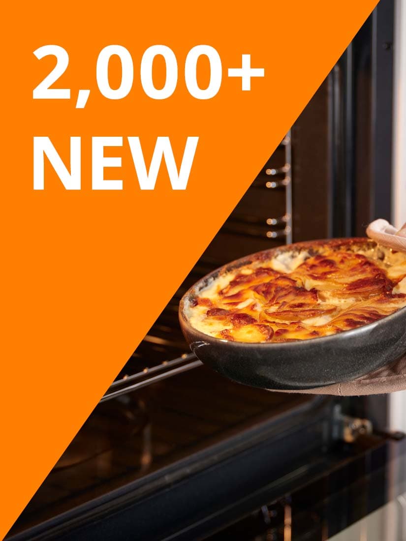 White text reads: "2,000+ NEW" on orange background. Hand in glove holding a dark grey glazed GLADELIG oven dish filled with food, in front of an oven.