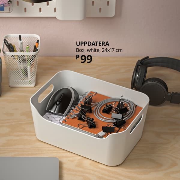 White UPPDATERA 24×17 cm storage box organizes a mouse, cables, and small electronics on a wooden desk, with headphones nearby; tidy, practical setup.