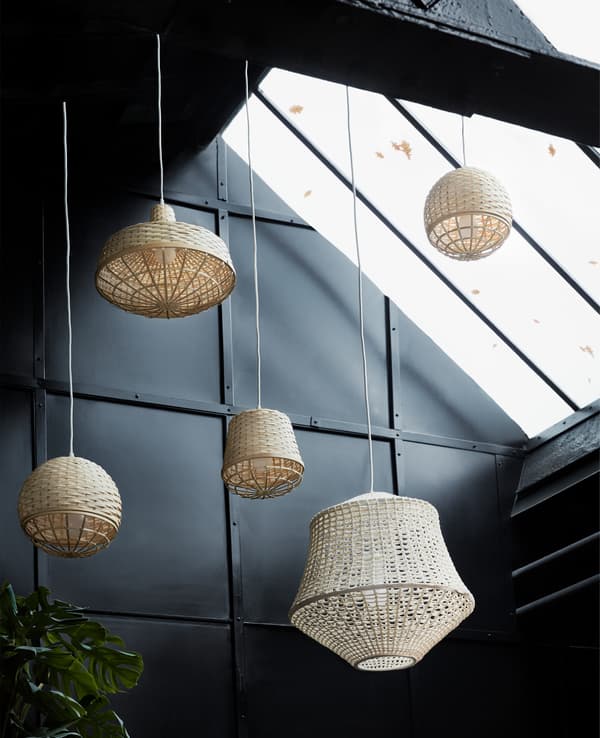 Wicker lanterns hanging up in a warehouse.