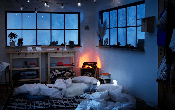 Wintery log-cabin style interior, mattresses on the floor made as temporary beds, LED night lights beside them. 