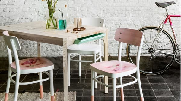 Witte IDOLF stoelen gepimpt met roze verf aan een houten tafel