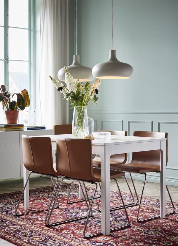 Witte IKEA EKEDALEN eettafel met vier BERNHARD stoelen in bruin leder.