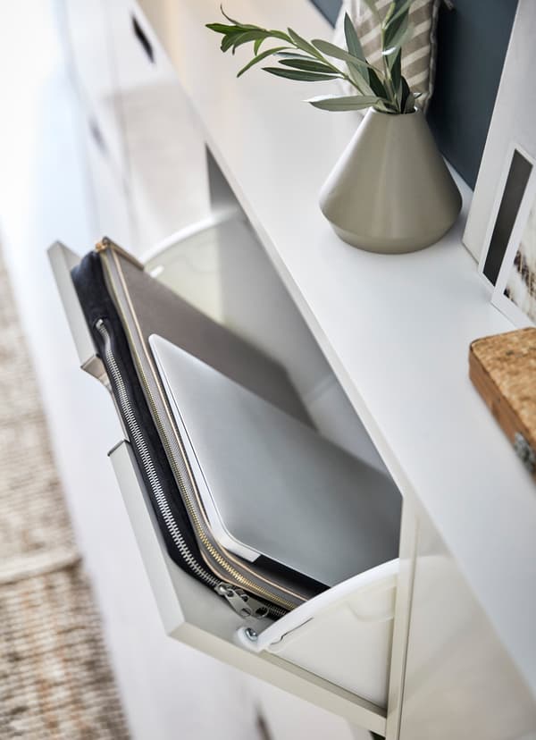 Witte IKEA STÄLL schoenenkasten; eentje staat open, waardoor de erin opgeborgen laptop en laptoptas zichtbaar zijn.