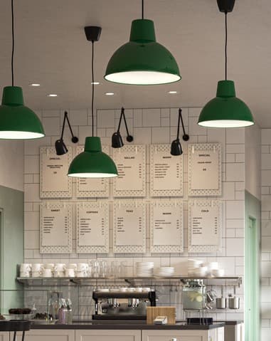 Witte ophangborden aan de wand, gerangschikt als een menukaart, met een koffiemachine, witte kopjes en borden, transparante glazen.