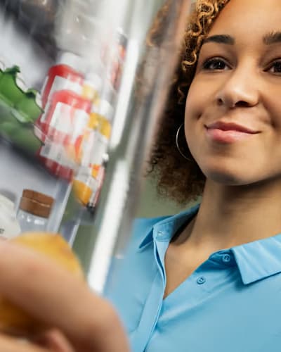 Woman going through her pantry reducing waste at home