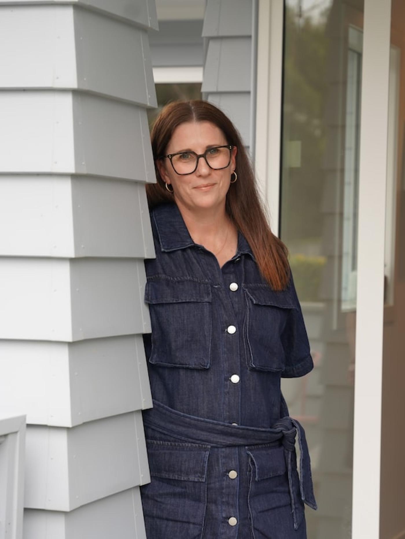 Woman in New Zealand standing at front door of home