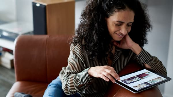Woman shopping on a tablet on a couch 