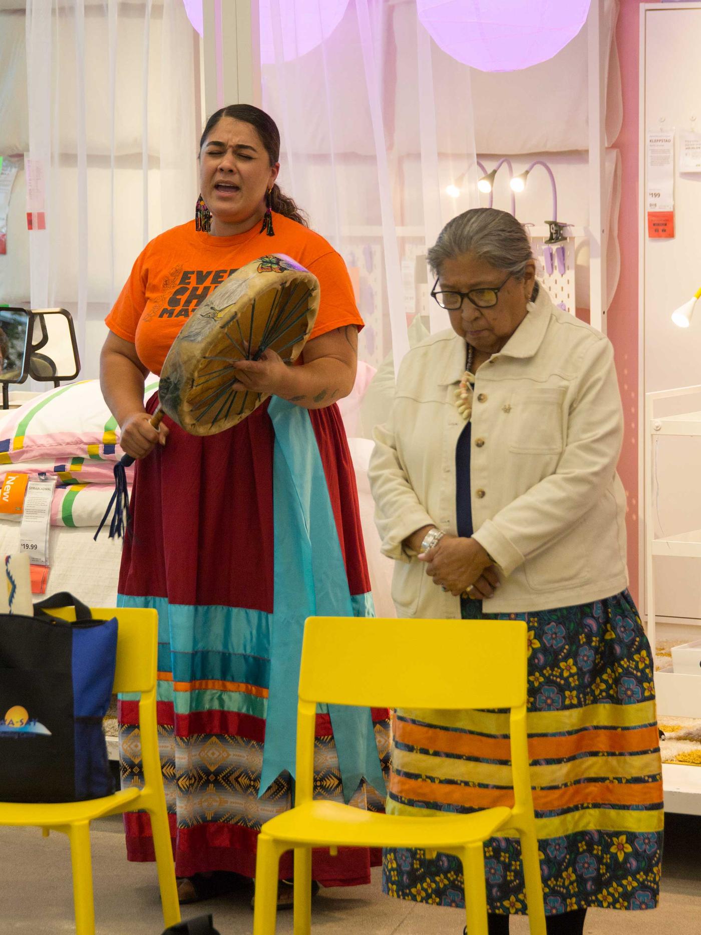 Woman singing and drumming.