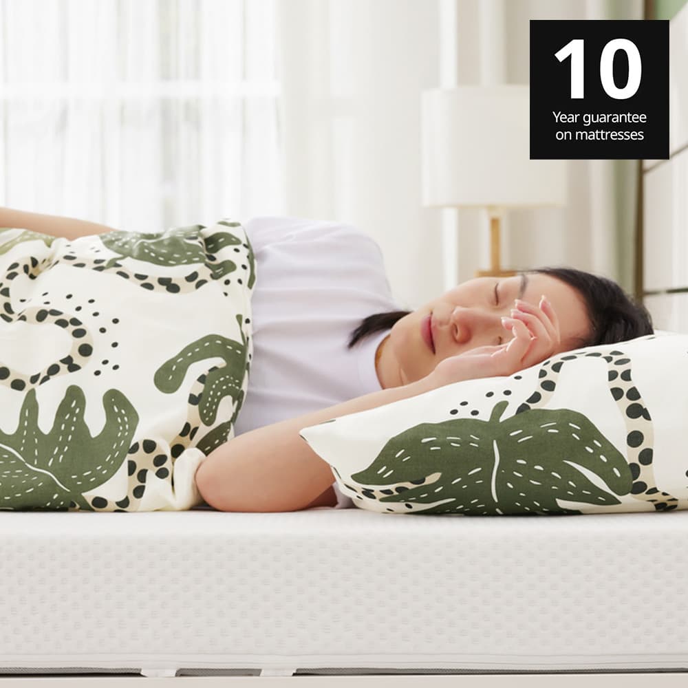 Woman sleeping on ÅKLABBEN natural latex mattress in a bedroom in Singapore. 10 year guarantee on IKEA mattresses.