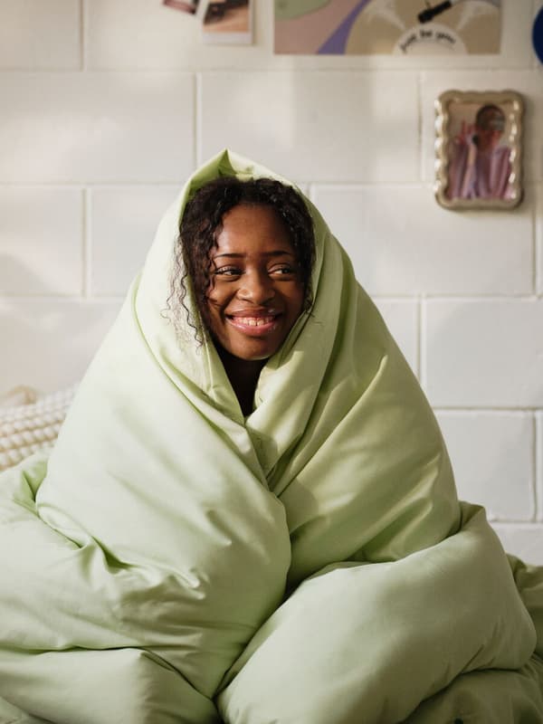 woman wrapped in green comforter