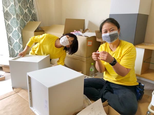 棚を組み立てる2人のスタッフ。