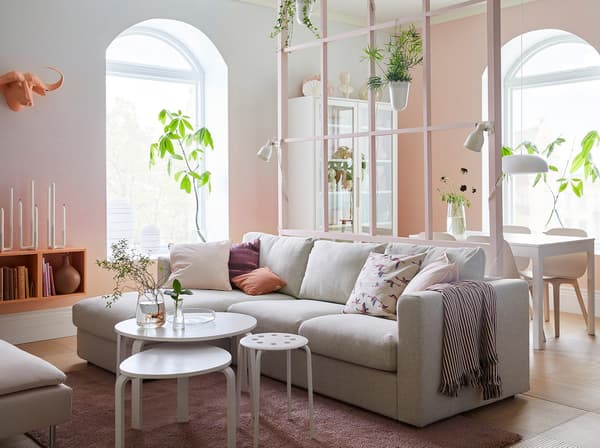 Woonkamer in roze en wit met beige VIMLE zitbank en chaise longues. Je ziet de eetzone op de achtergrond.