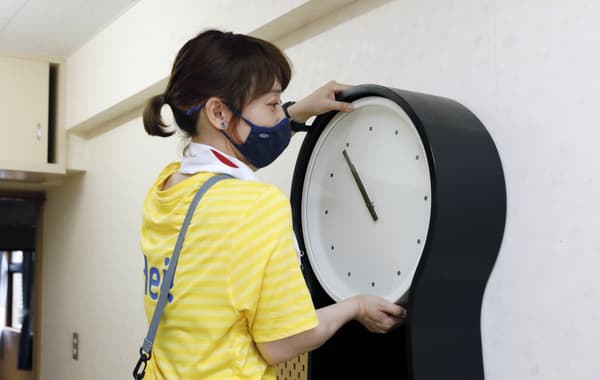 時計を飾っているコワーカー。