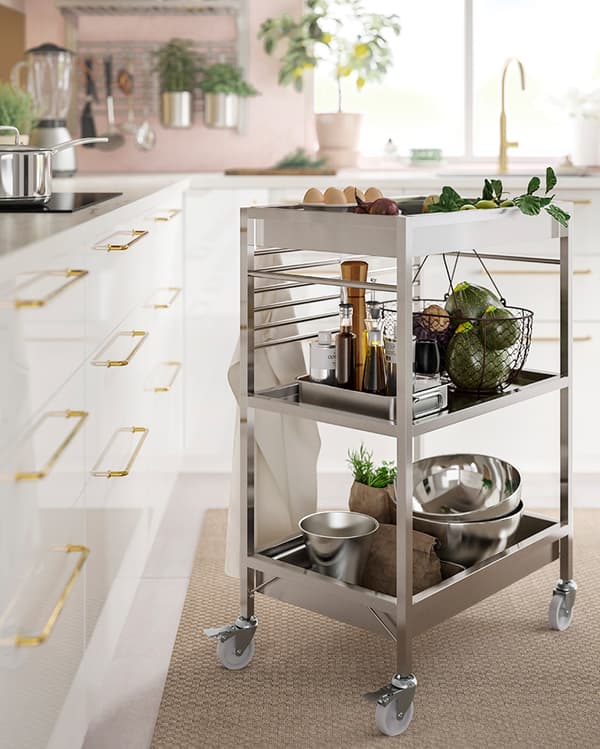 Wózek ze stali nierdzewnej IKEA KUNGSFORS z akcesoriami kuchennymi i świeżymi produktami.