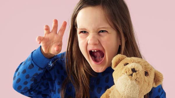 Young girl with a soft toy lion cub