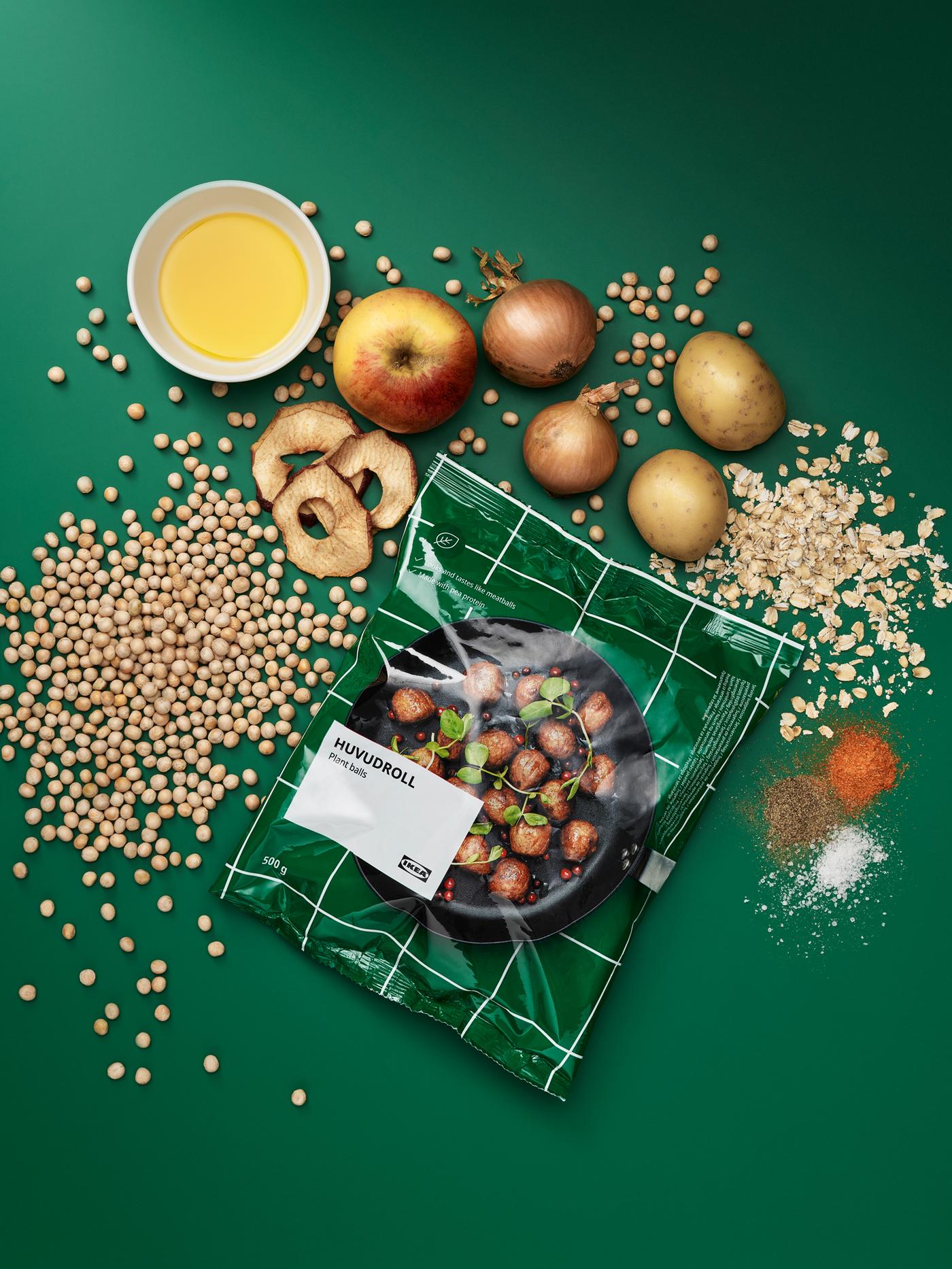 Zak met HUVUDROLL plantballetjes met daaromheen de onverwerkte ingrediënten: erwten, haver, aardappelen, uien, appels en kruiden.
