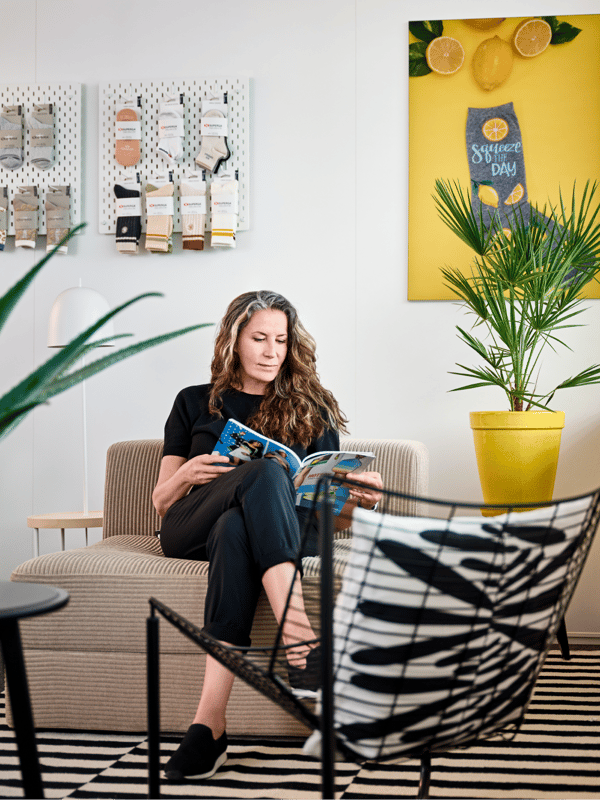 zakelijk uitziende vrouw zit op een bank en leest een magazine