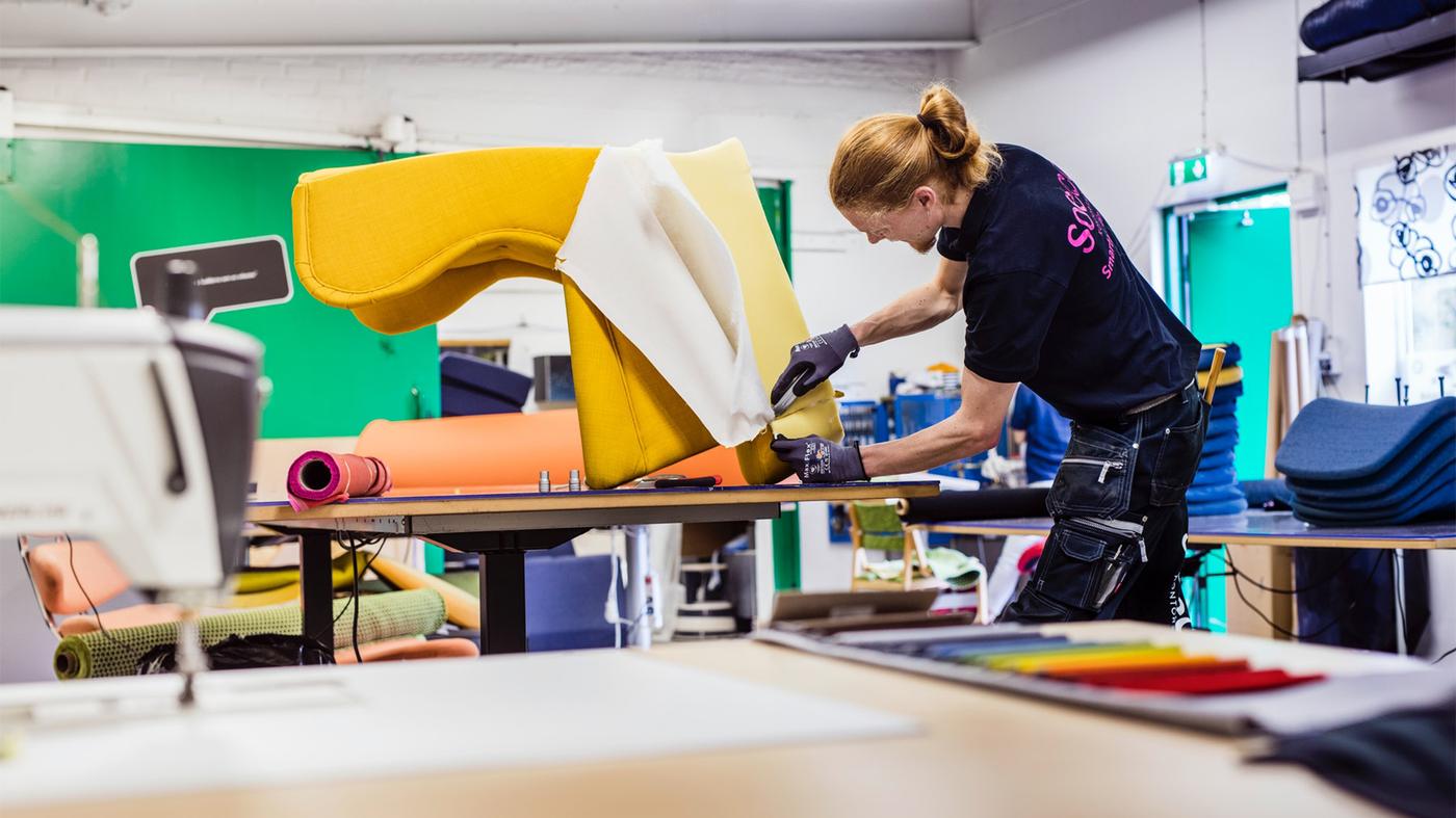 Zaměstnanec IKEA opravuje potah křesla. 