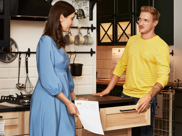 Zamestnanec IKEA pomáha zákazníčke s výberom kuchyne