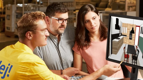 Zaměstnanec IKEA pomáhá zákazníkům s plánováním kuchyně