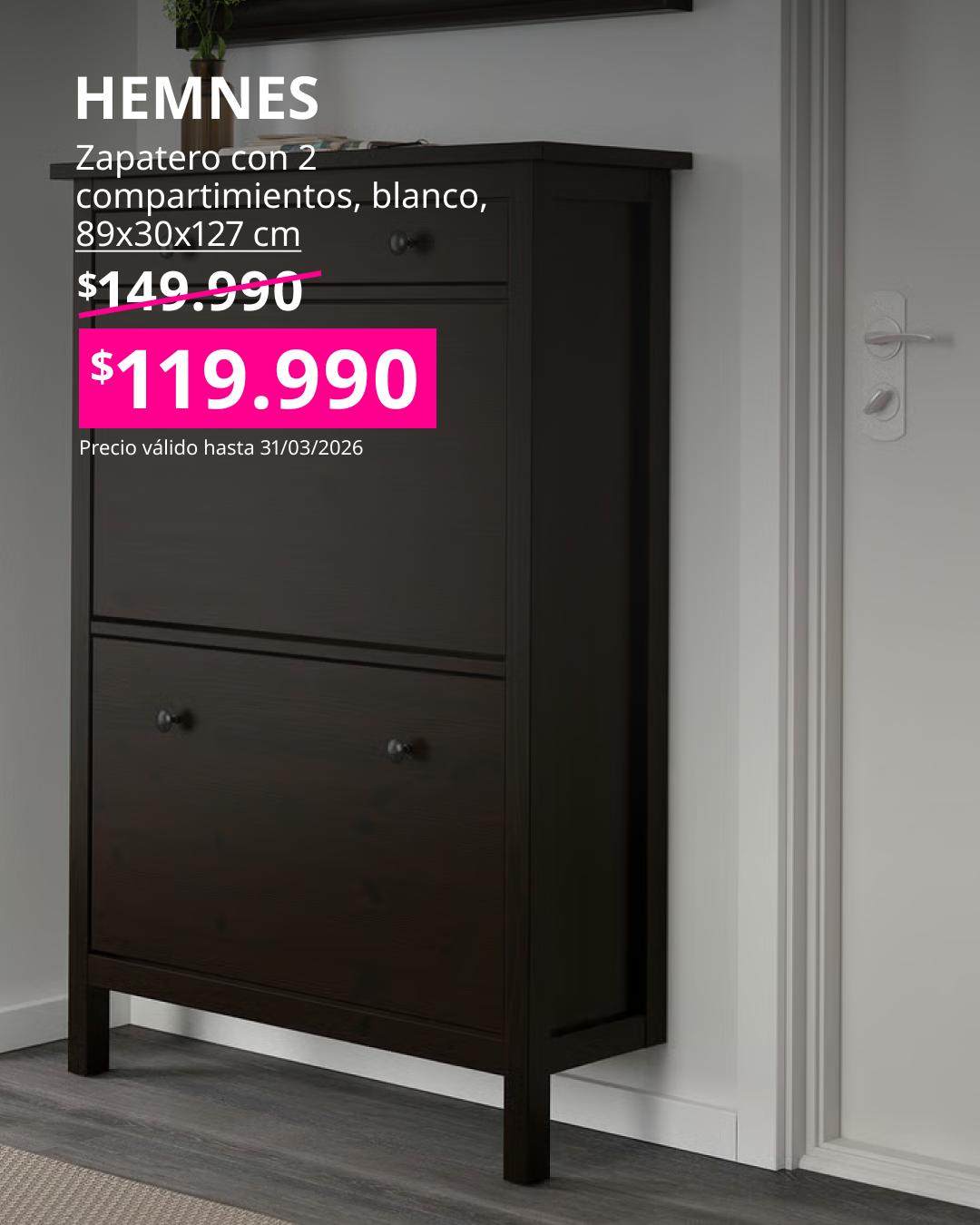 Zapatero HEMNES de Ikea en color negro con dos compartimientos, mueble vertical de madera con tiradores redondos, ubicado en un recibidor con pared blanca y piso gris.