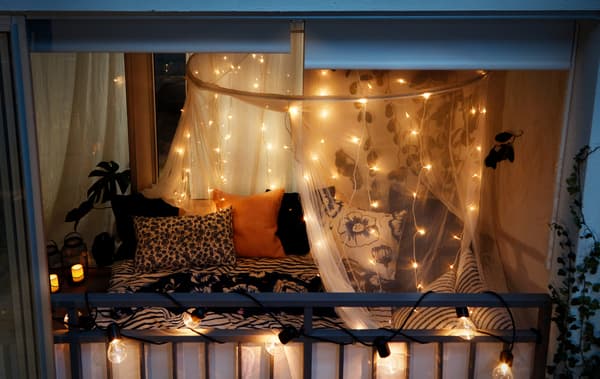 Zárt erkély, éjszaka, hangulatvilágításokkal.