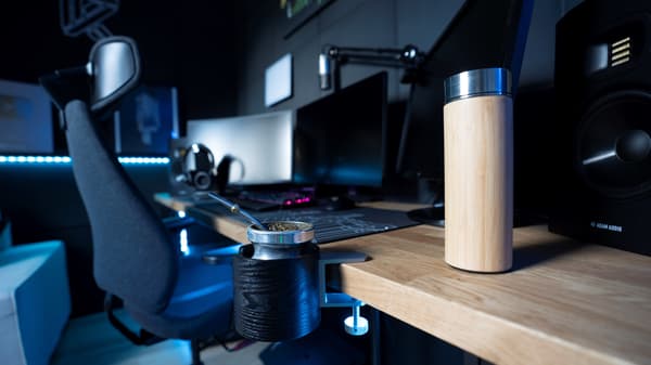 Zbliżenie na blat biurka z ekranami komputera i fotelem GRUPPSPEL.