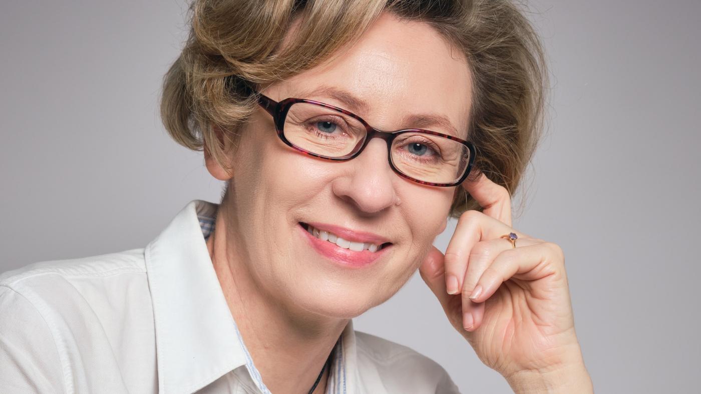 Zdjęcie przedstawia ludzi rozmawiających w biurze.