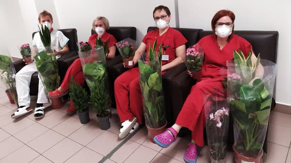 Zdravotníci v červených pracovních kombinézách sedící na křeslech IKEA.