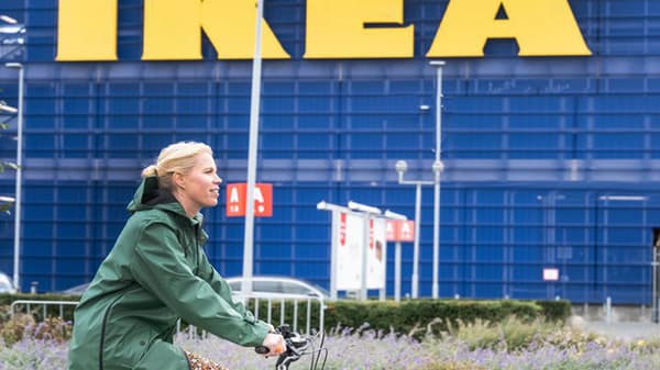 Žena na kole projíždí okolo obchodního domu IKEA