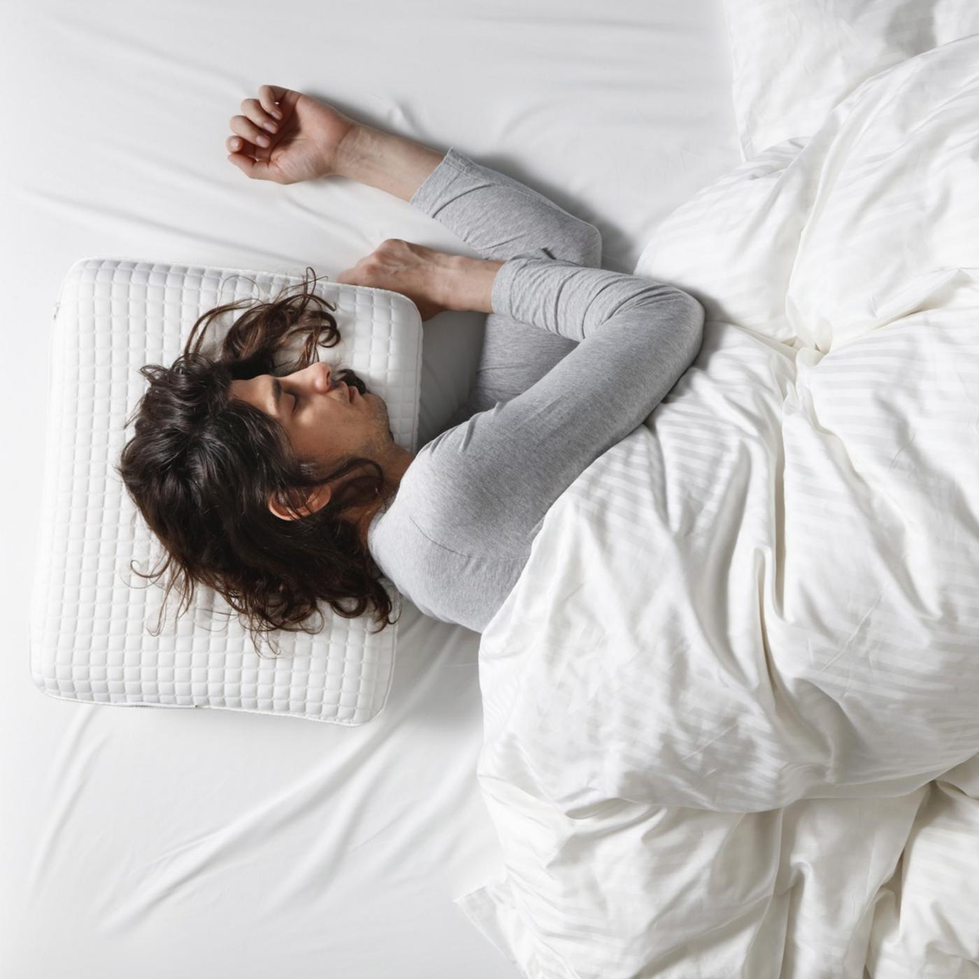 Žena spava na krevetu, na boku.