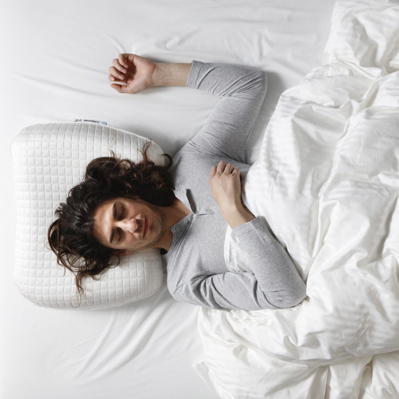 Žena spava na krevetu, na leđima.