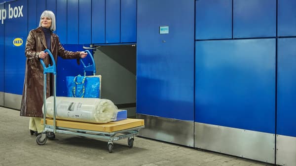 Žena v dlouhém kabátu si vyzvedla zboží z výdejního boxu IKEA