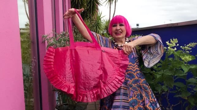 Zhanda Rhodes kezében rózsaszín fodros IKEA táska.