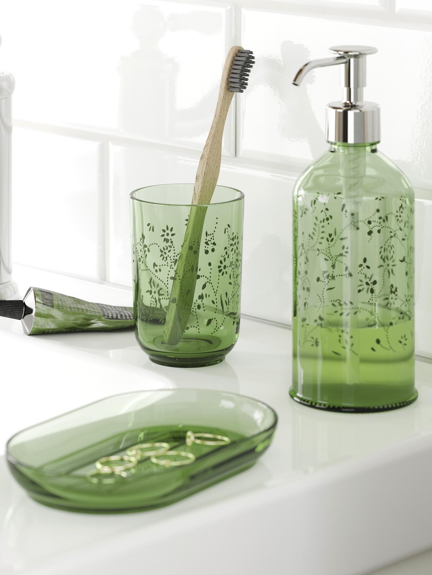 Zielony 3-częściowy zestaw łazienkowy GROSSJÖN stoi na białęj umywalce.