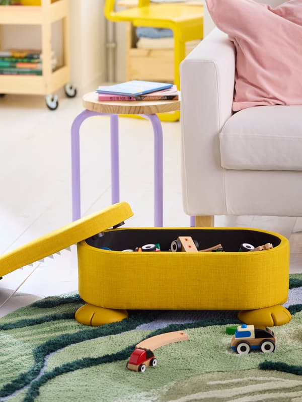 Žltá taburetka GREJSIMOJS na zelenom koberci GREJSIMOJS.