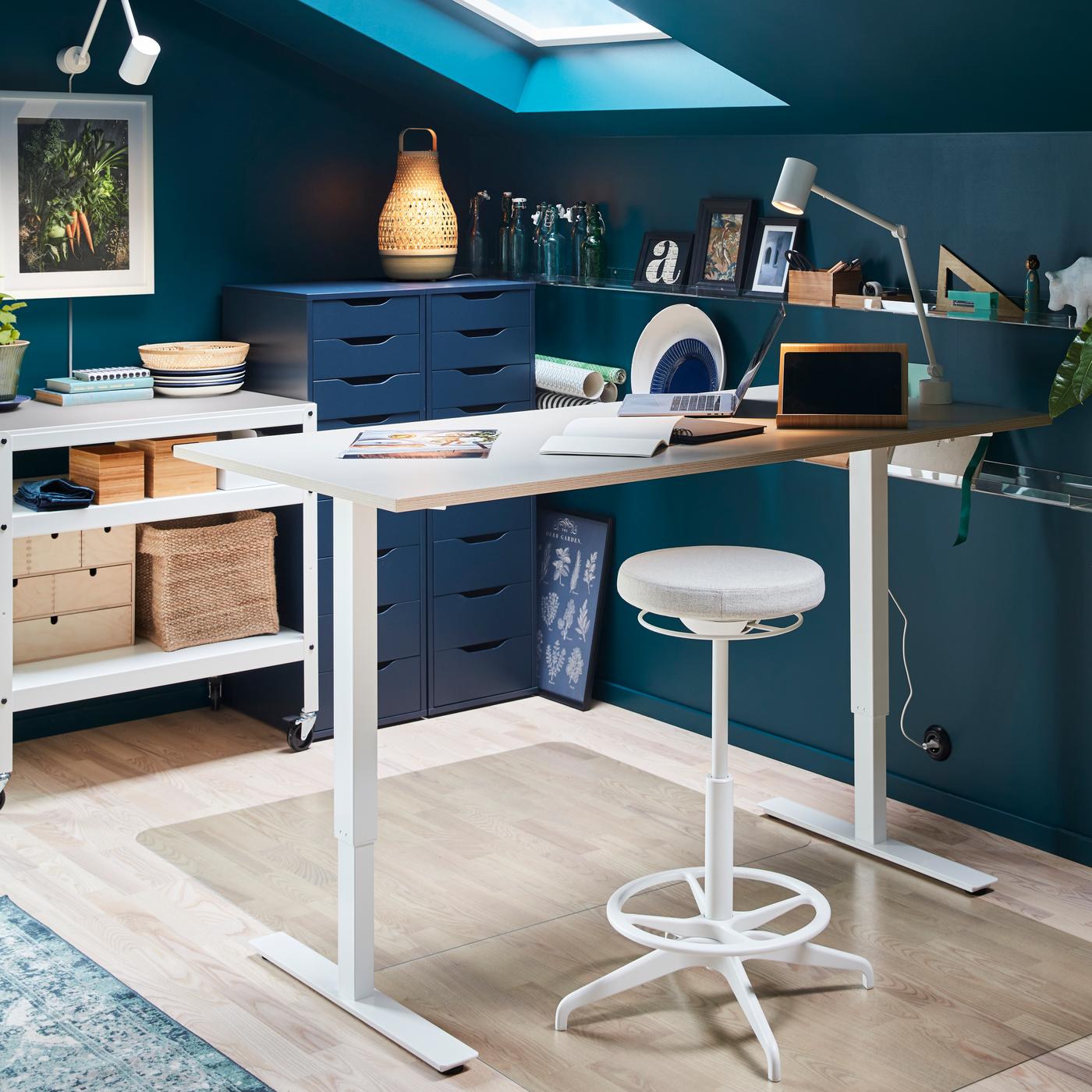 Zona de estudio con paredes azules. Junto a la pared hay un escritorio y un piso blancos, con cuadernos y lápices encima.