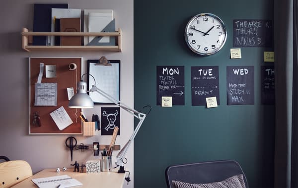 Zona de estudo dun dormitorio xuvenil cun escritorio, unha lámpada de traballo, estantes, un portapapeis, un reloxo, un taboleiro de anuncios e un horario semanal na parede.