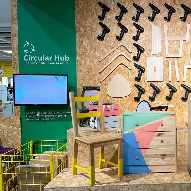 zu sehen ist der IKEA Zweites Leben Shop mit einem Monitor sowie einem Holz Sessel und einem Holz Regal.