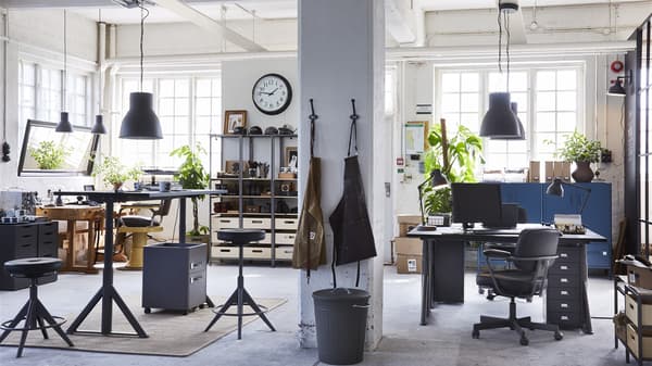 zu sehen ist ein offener Raum mit IKEA Einrichtung die Stühle, Tische und Regale enthält. Alles ist in einem dünklerem Blauton gehalten.