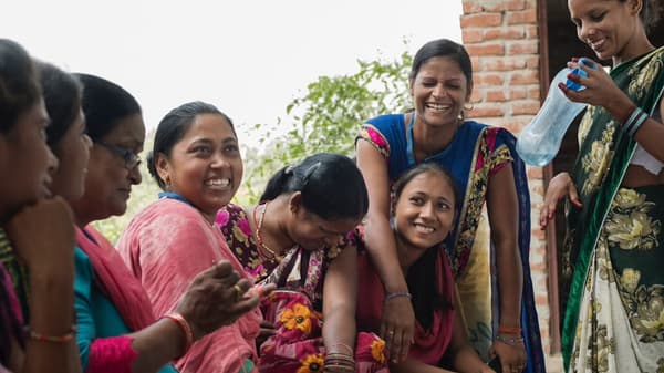 zu sehen ist eine Indische Familie die glücklich beisammen sitzt