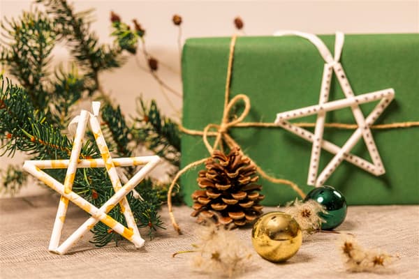 Zwei aus Papier-Trinkhalmen gebastelten Sterne als Christbaumschmuck und Geschenkverzierung.