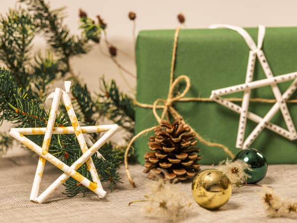 Zwei aus Papier-Trinkhalmen gebastelten Sterne als Christbaumschmuck und Geschenkverzierung.