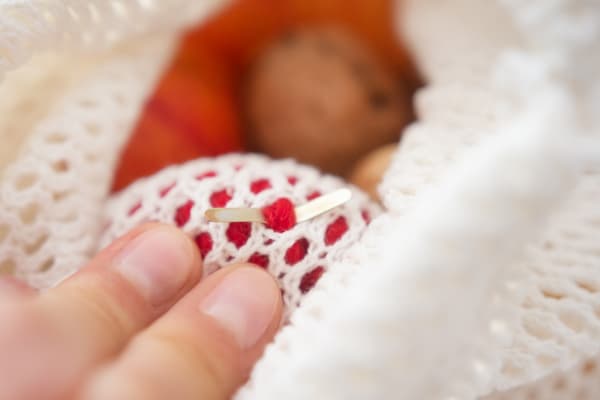 Zwei Finger liegen auf einem Stoffsäckchen.