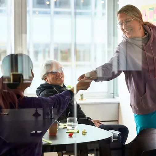 Zwei Frauen begrüßen sich durch ein Hände schütteln