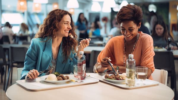 Zwei Frauen, die im IKEA Restaurant sitzen und Köttbullar essen.
