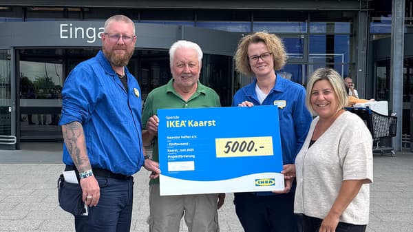 Zwei Frauen und zwei Männer stehen vor dem IKEA Einrichtungshaus in Kaarst und halten gemeinsam einen Spendenscheck in Höhe von 5.000€ .