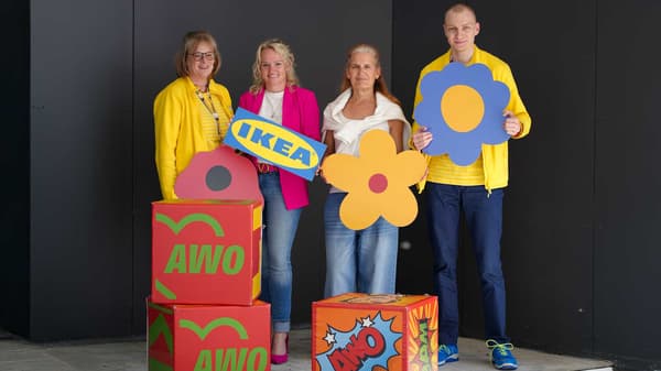 Zwei IKEA Mitarbeitende und zwei Frauen stehen zusammen.